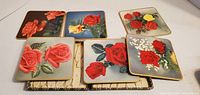 six coasters with rose images displayed on case lid