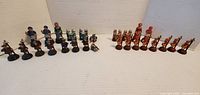 Both blue and red pewter chess groups aligned, showing quantity and comparative theme