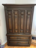 Front view of dark brown paneled armoire