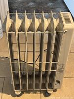 Top view of six-fin oil-filled heater showing grills, fins, cord and casters