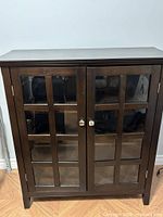 Front view of espresso cabinet showing two glass-paneled doors and silver knobs