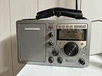 Front view of Grundig S350 radio showing display, controls, speaker and handle