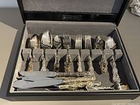 Open box showing full 52-piece flatware set