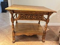 Full view of oak two-tier side table showing top, apron, legs and lower shelf