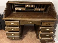 Desk with roll-top open showing drawers and cubbies