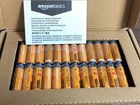 Open box showing 48 Amazon Basics AA batteries and multilingual insert card