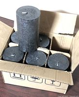 Open box showing six black pillar candles