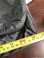 close-up of zipper and fabric with tape measure indicating approximately 30 cm width