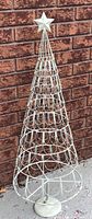 Full view of metal wire Christmas tree frame with star topper