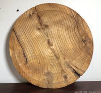 Front view of round wooden slab displaying grain and knots