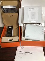 Doorbell, thermostat, accessory and manuals in open boxes