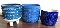 Three blue textured ceramic planters side by side
