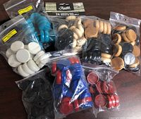 Group shot of all eight bags of coloured Crokinole discs