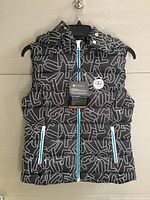 Front view of LPGA grey print vest on hanger showing pattern, zippers, chest patch, tags attached