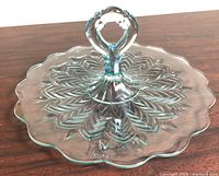 Full view of round glass sandwich server showing scalloped edge and handle