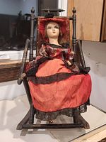 Full view of doll seated, showing dress and size reference