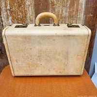 Front of suitcase showing vellum leather, handle and latches