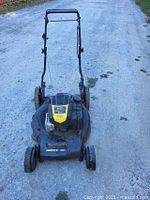Front view of mower showing deck, wheels, handle and engine cover