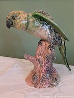 Front view of Beswick parrot figurine showing colours and floral stump