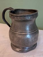 Front view of pewter jug showing HALF PINT lettering and baluster shape