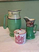 Group shot of large green jug, smaller scene jug and jam jar