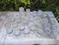 All 32 jars arranged on surface showing variety of sizes and lids
