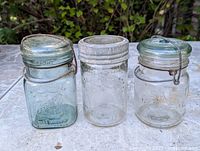 Front view of three jars showing lids and embossing