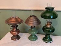Group shot showing three vintage miniature oil lamps