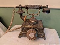 Full view of ornate brass rotary phone