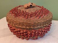 Full view of basket with lid showing red curled ash decoration and bow