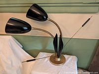 Full view of dual gooseneck lamp showing base, shades, rods