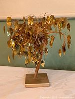 Front view of metal money tree showing gold leaves and base