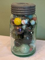 Front view of aqua Crown jar filled with marbles