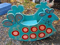 Full side view of wooden folk art rocker showing overall shape and paint design