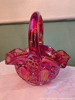 Full view of ruby iridescent glass basket showing handle and ruffled rim