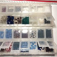 Organizer open showing multiple compartments filled with assorted beads