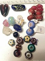 Overview of assorted beads and pendant with ruler for scale