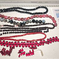 All eight bead strands laid out under ruler, showing colours, shapes and lengths