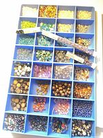Open organizer showing multiple compartments filled with assorted beads