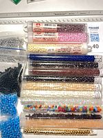 Grouped view of tubes and bags of assorted glass beads
