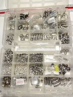 Top-down view of organizer showing assorted silver-tone beads, findings and storage compartments