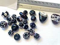 Group of all lampwork beads near ruler for scale
