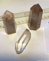 All three quartz points standing near ruler for size reference