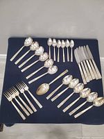 Full set laid out showing spoons, forks, knives