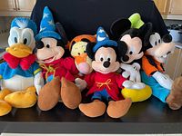Six Disney plush toys lined on surface