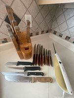 Overall lot showing Philips electric knife, bamboo block with wood-handled knives, vintage and utility knives laid out