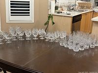 Entire 49-piece crystal glassware collection arranged on table