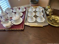 Full lot showing porcelain sets, metal trays, and brass pieces