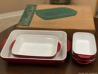 Group shot of Pampered Chef boxed baker and stacked KitchenAid red ceramic bakers