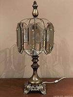 Lamp unlit showing brass-tone base, glass panels, wiring and finial